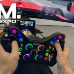 Le volant Conspit 280FR en main sur le stand Conspit de la SimRacing Expo 2026, avec le CSD Nano clipsé sur la base