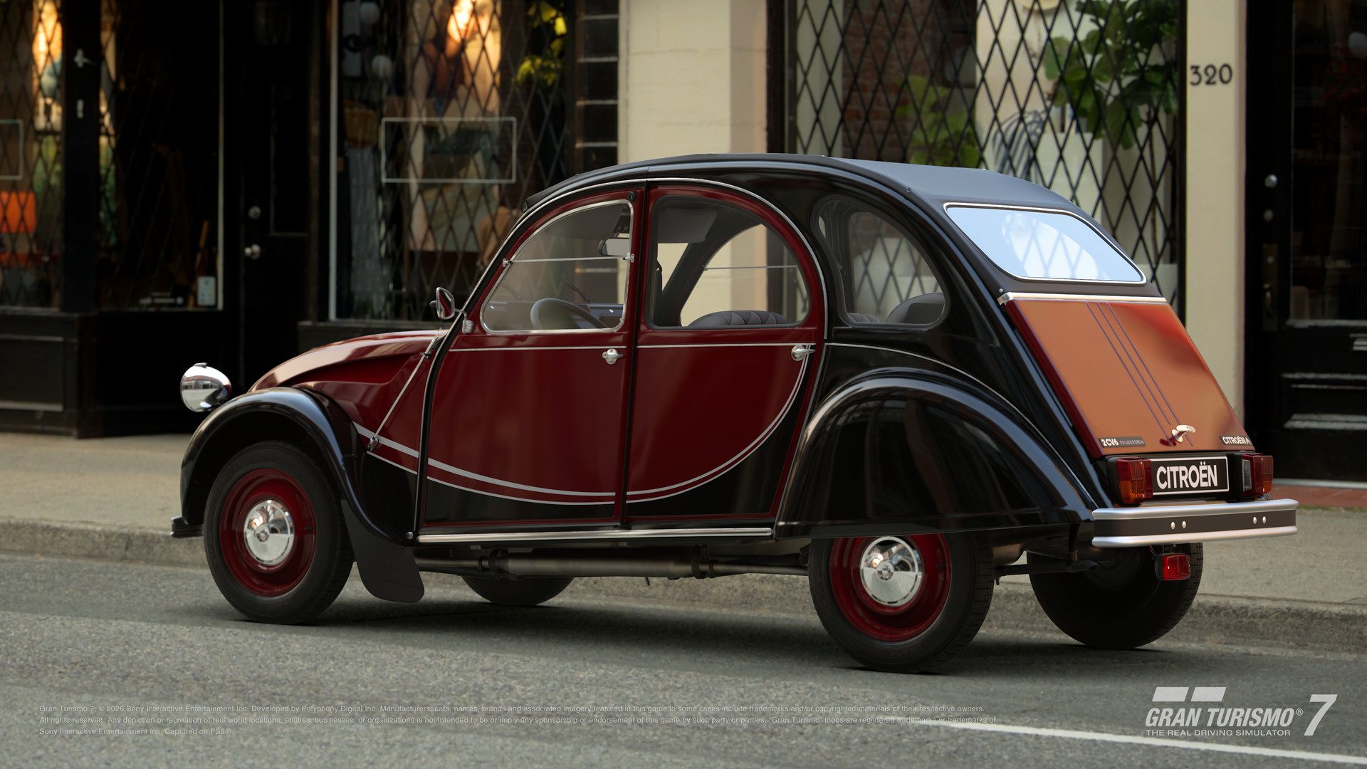 La Citroën 2 CV 6 Charleston '86 rouge et noire garée devant une boutique