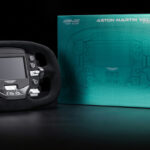 Volant Simagic Aston Martin Valkyrie posé à côté de son coffret vert Aston Martin, visuel officiel Simagic