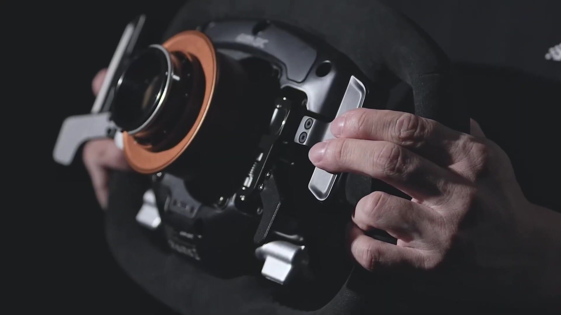 Dos du volant Simagic Aston Martin Valkyrie tenu à deux mains, avec ses palettes et son quick release