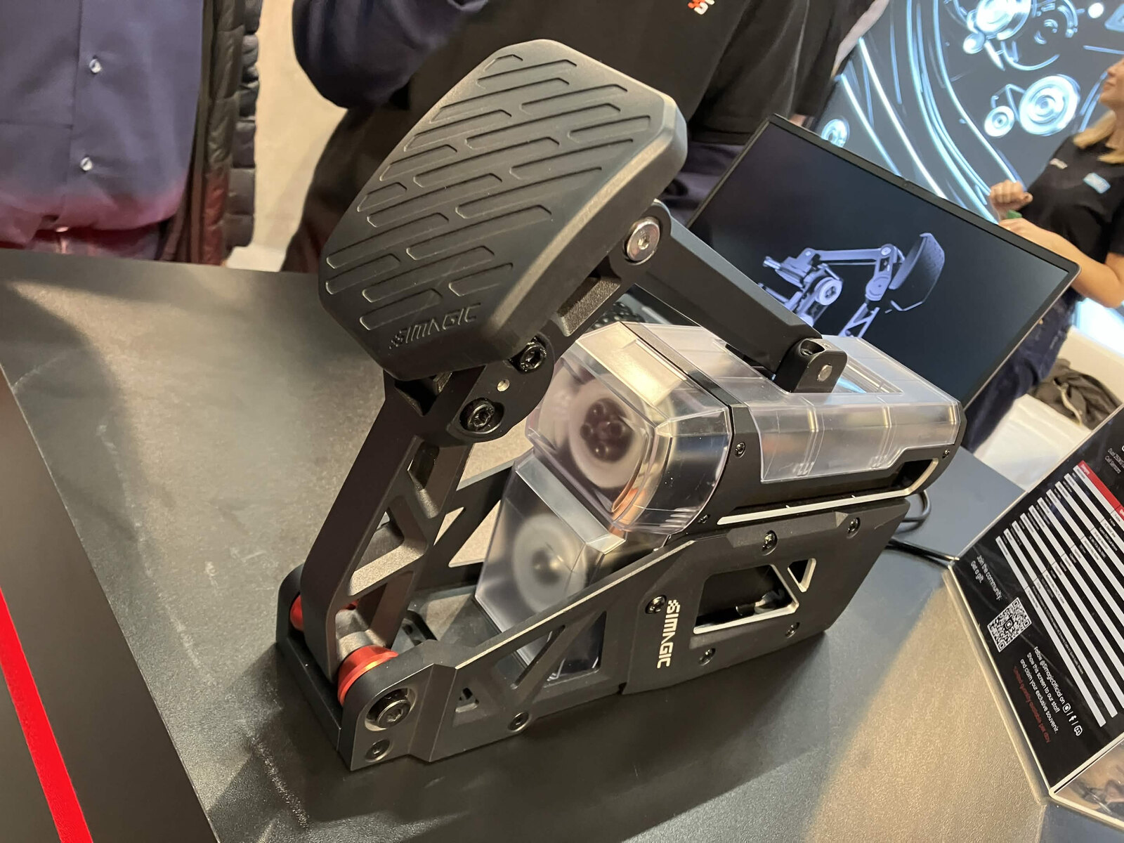La Simagic P-Active exposée avec un carter transparent, qui laisse voir la courroie et le moteur placé haut