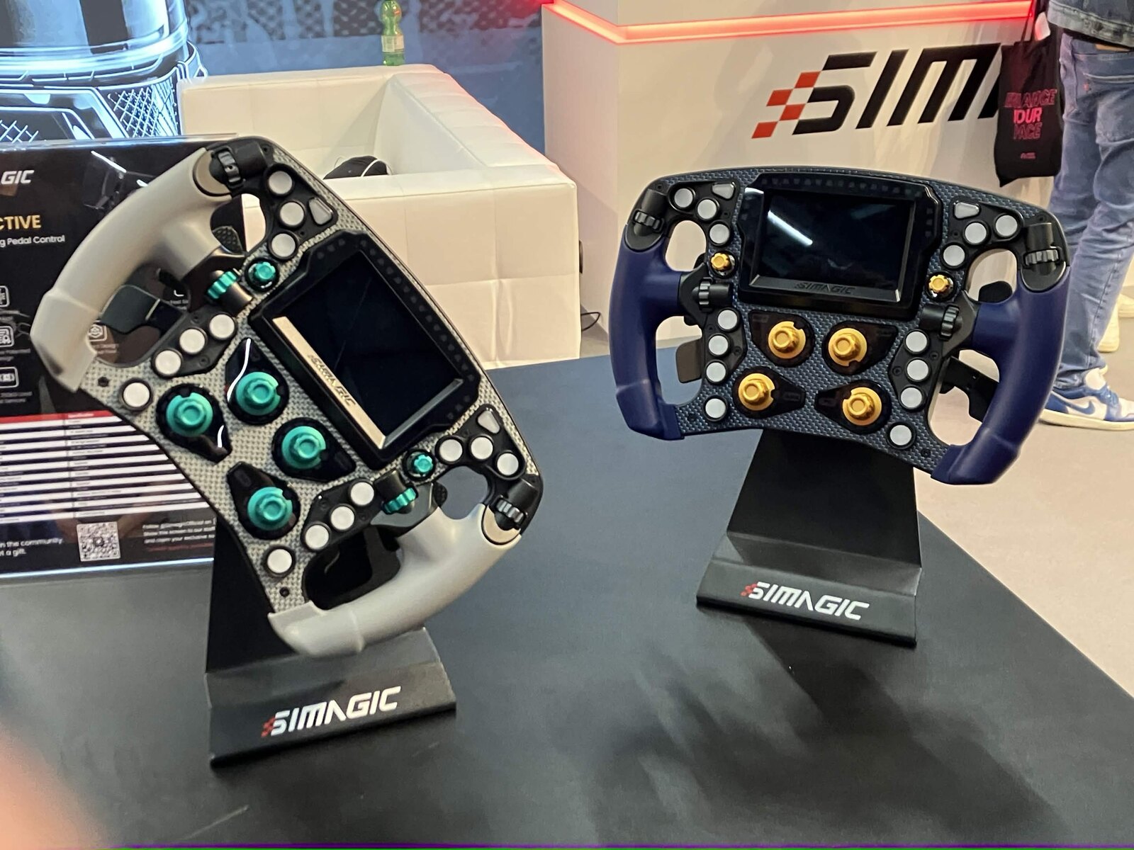 Le volant Simagic Zeus Formula en finition grise à boutons verts, à côté de sa version bleue