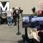Visiteurs sur un stand de la SimRacing Expo 2026 à Francfort, avec le logo du salon