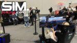 Visiteurs sur un stand de la SimRacing Expo 2026 à Francfort, avec le logo du salon