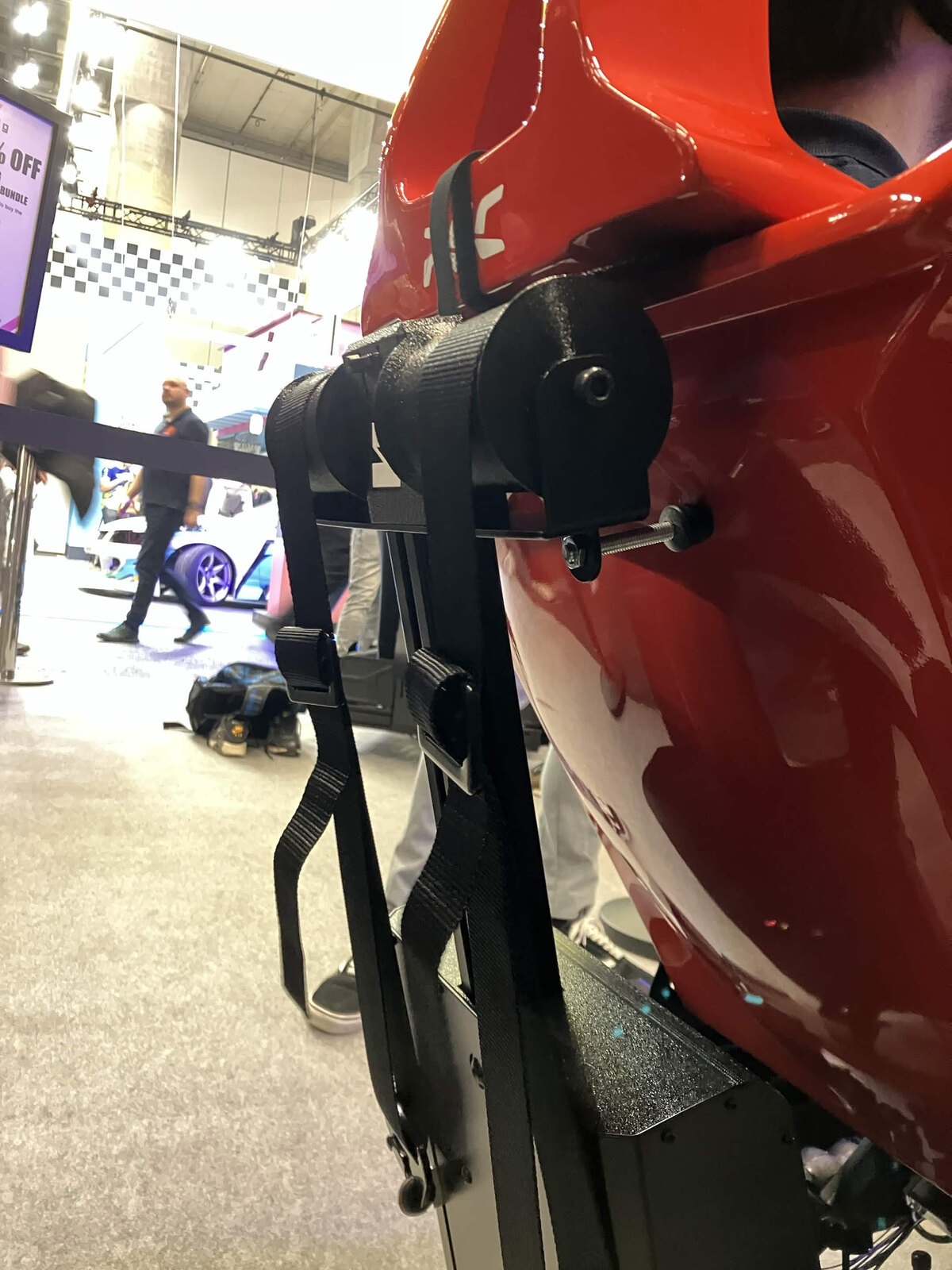 Le Simrig SBM fixé derrière le baquet, avec les sangles du harnais qui passent dans le tendeur