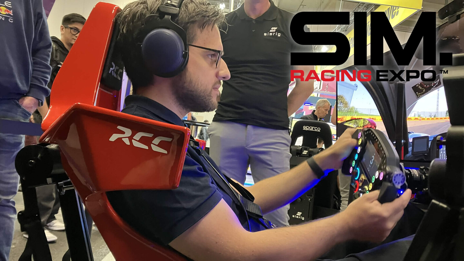 Essai du Simrig SBM sur le rig de Naga Racing au stand Simrig de la SimRacing Expo 2026, harnais serré et mains sur le volant