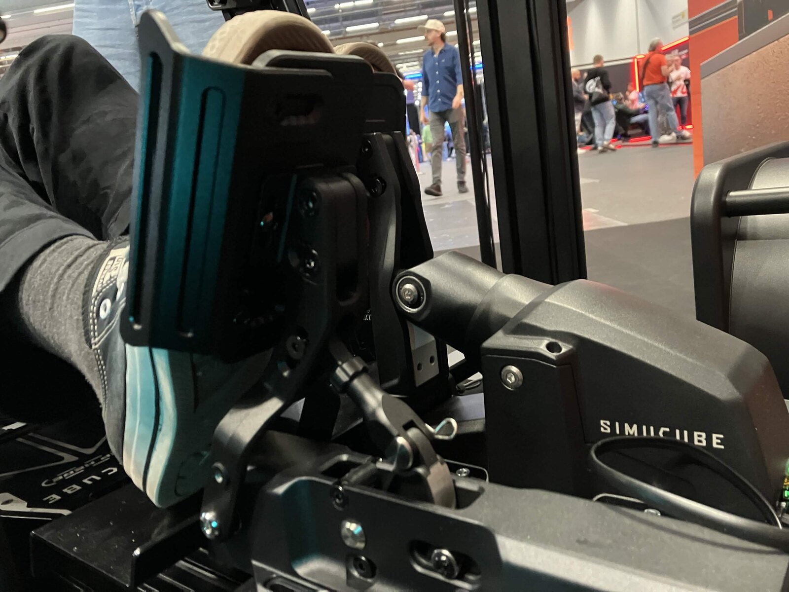 Gros plan sur la plaque de pédale agrandie de l'ActivePedal Sport, sous le pied, sur le stand Simucube