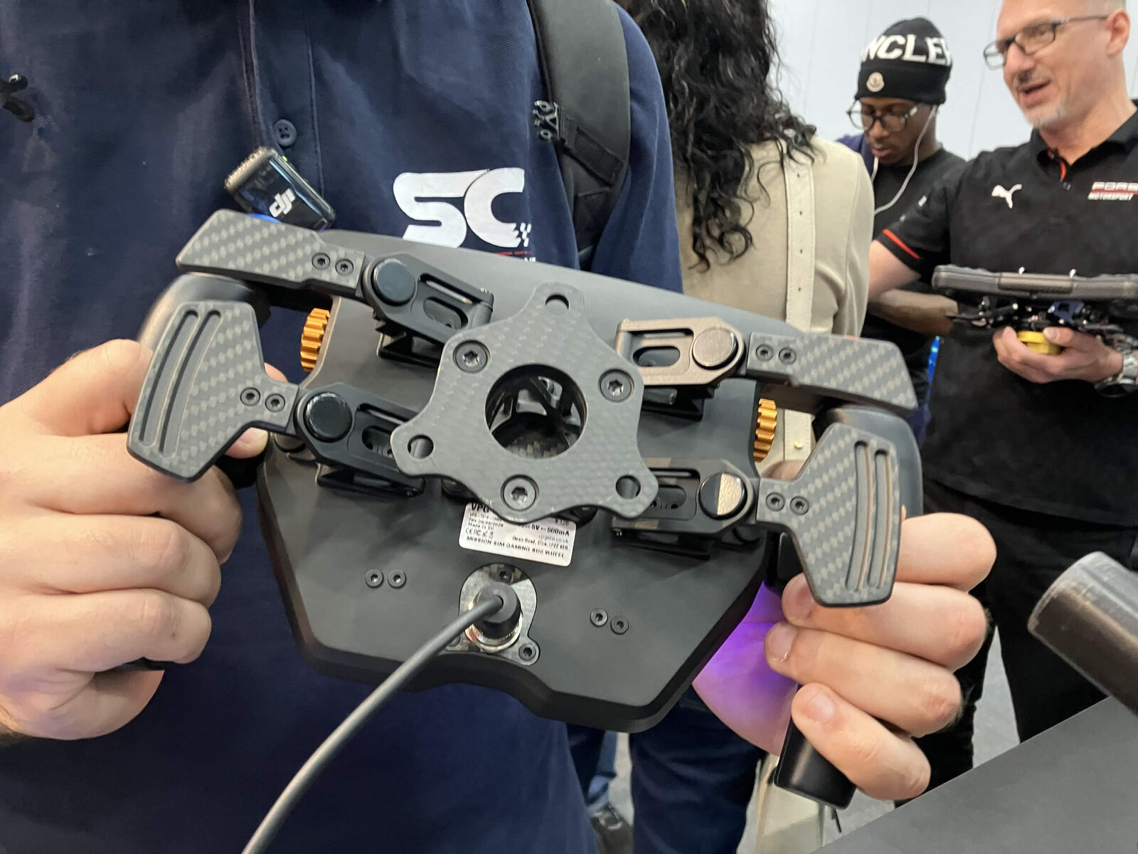 Le dos du VPG Mission Sim tenu en main sur le stand, avec ses deux jeux de palettes et sa platine de fixation